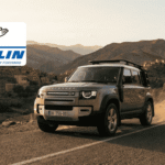 Un 4x4 Land Rover équipé de pneus Michelin roulant sur une route sinueuse dans les montagnes de l'Atlas au Maroc, avec le logo Michelin officiel.